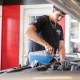 technician adding fluid and lubricants under hood of vehicle.