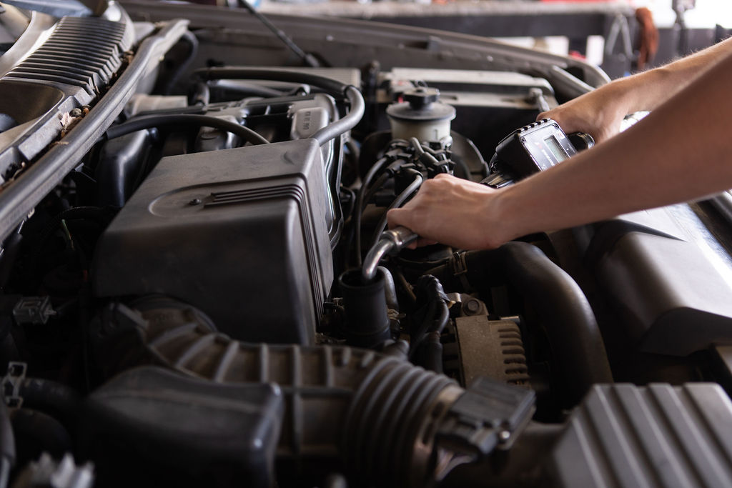 Hutchens(501) (1) Mechanic changing the oil under the hood of a vehicle
